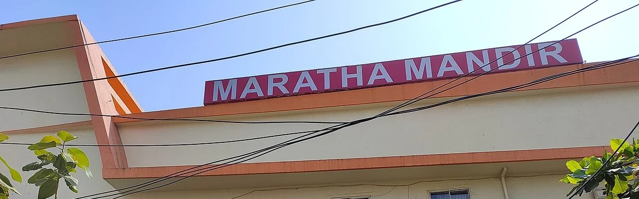 Maratha Mandir cinema’s rooftop name sign and cream-and-orange upper facade in2022