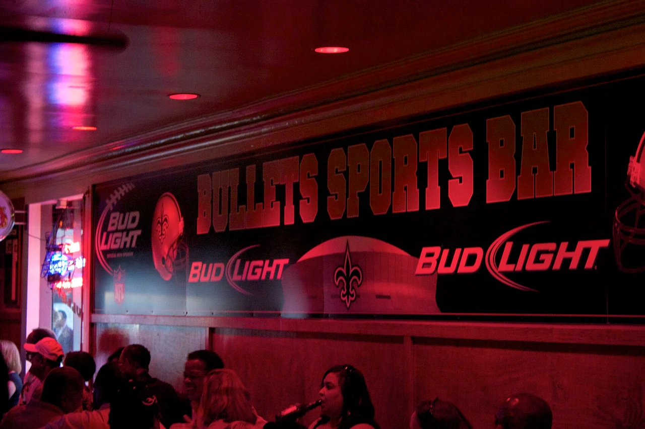 Red-lit interior of Bullet’s Sports Bar, with its venue name on the wall