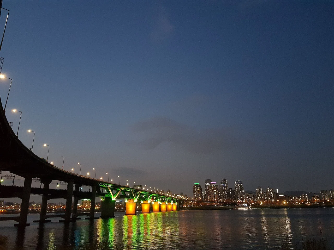 Cheongdam Bridge's double-deck span and lit piers across the Han River at dusk, 2018