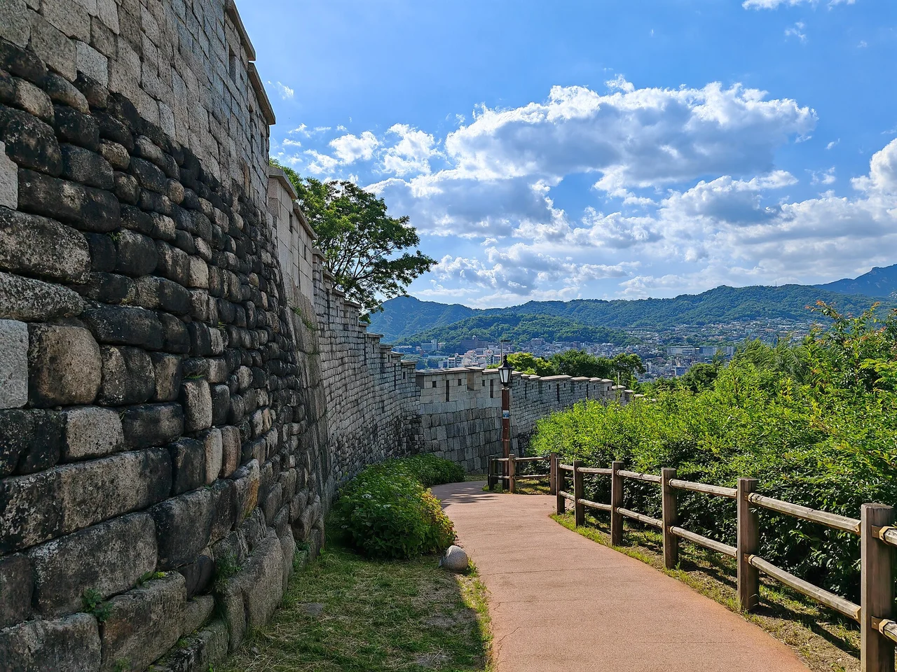 Path beside the old city wall in Naksan Park, with Seoul hills beyond