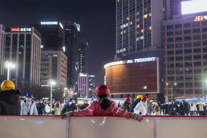 Skaters on Seoul Plaza’s outdoor ice rink at night.