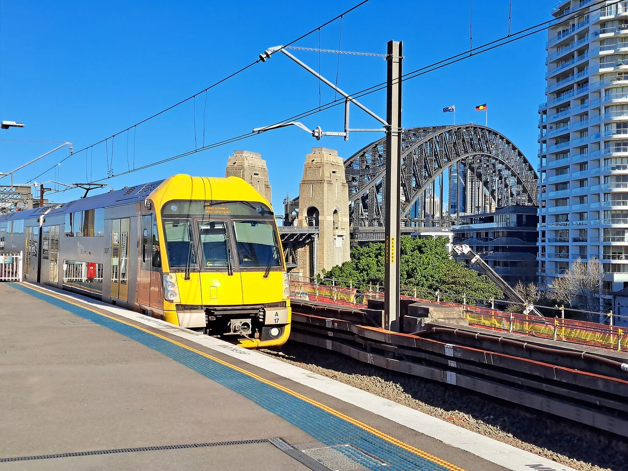 A train at Milsons Point with Sydney Harbour Bridge behind it