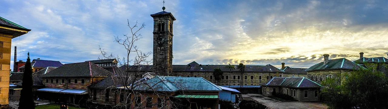 Wide view of the Kirkbride complex and tower at Callan Park at sunset