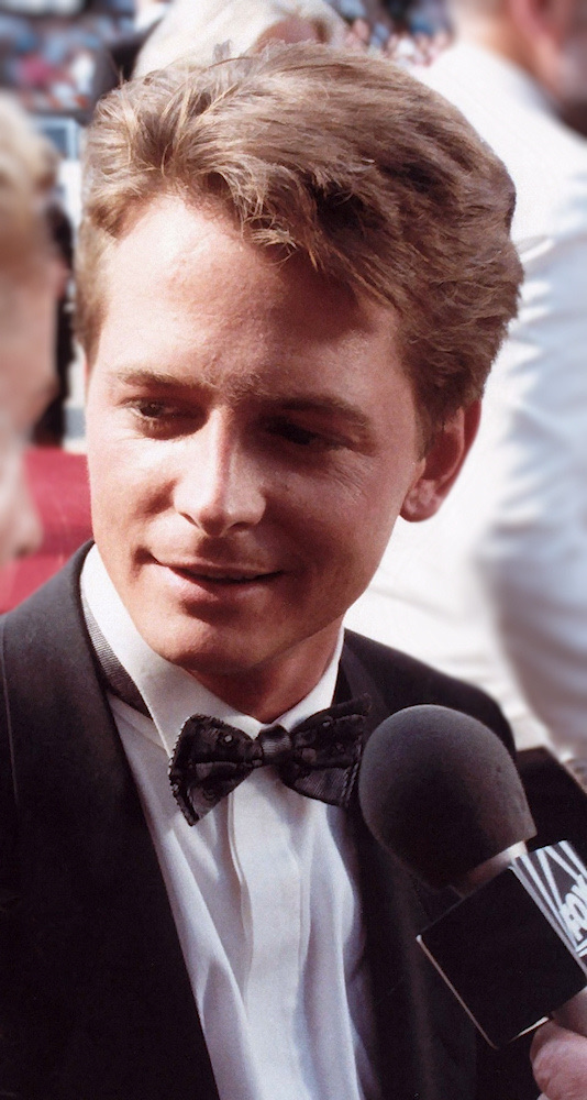 Michael J. Fox in a dinner jacket and bow tie, smiling, at the 1988 Emmy Awards