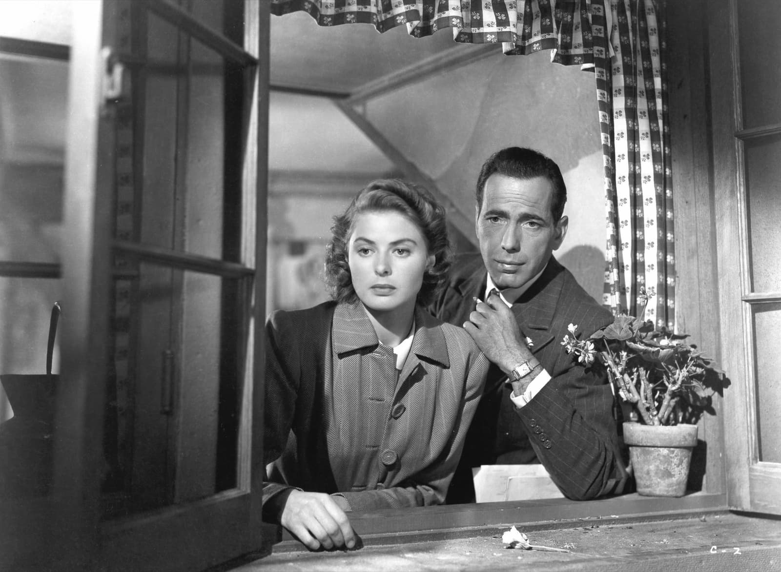 Ingrid Bergman and Humphrey Bogart lean on a window ledge in a 1942 publicity still