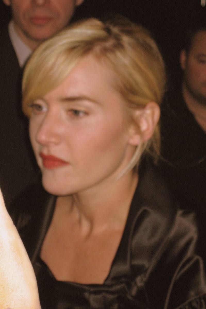 Kate Winslet with short blonde hair, looking down and to one side