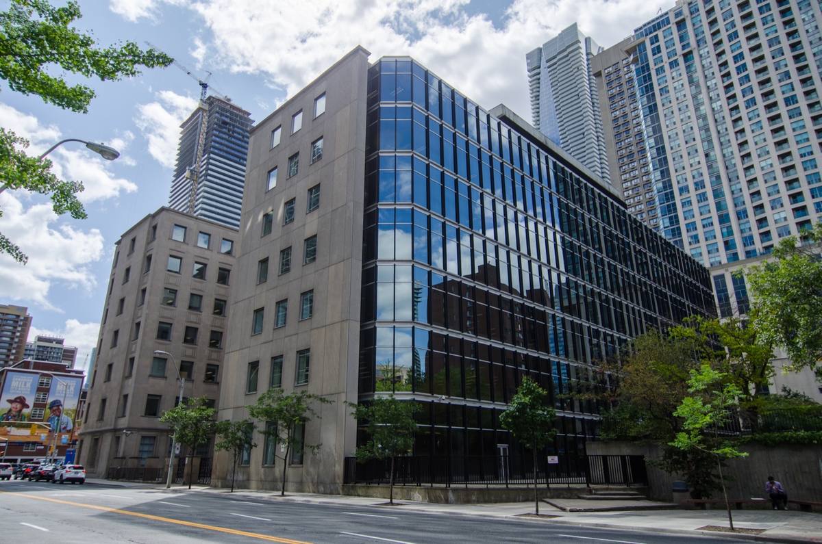 A grey office building with glass bays on a city corner