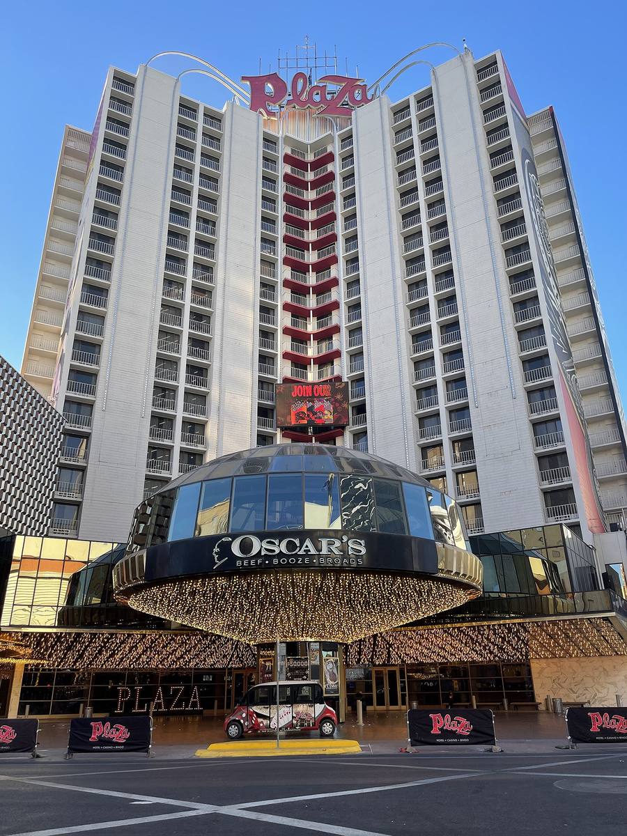 A tall hotel with a lit glass dome over its entrance