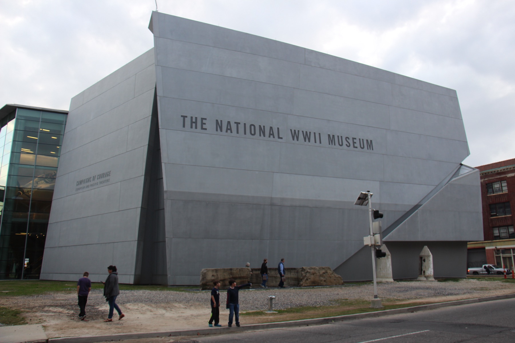 A large grey angular museum building with its name on the wall