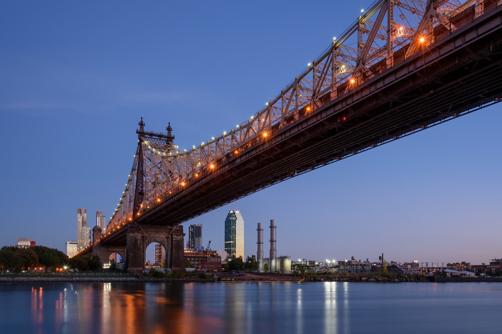 A steel cantilever bridge over the East River at dusk