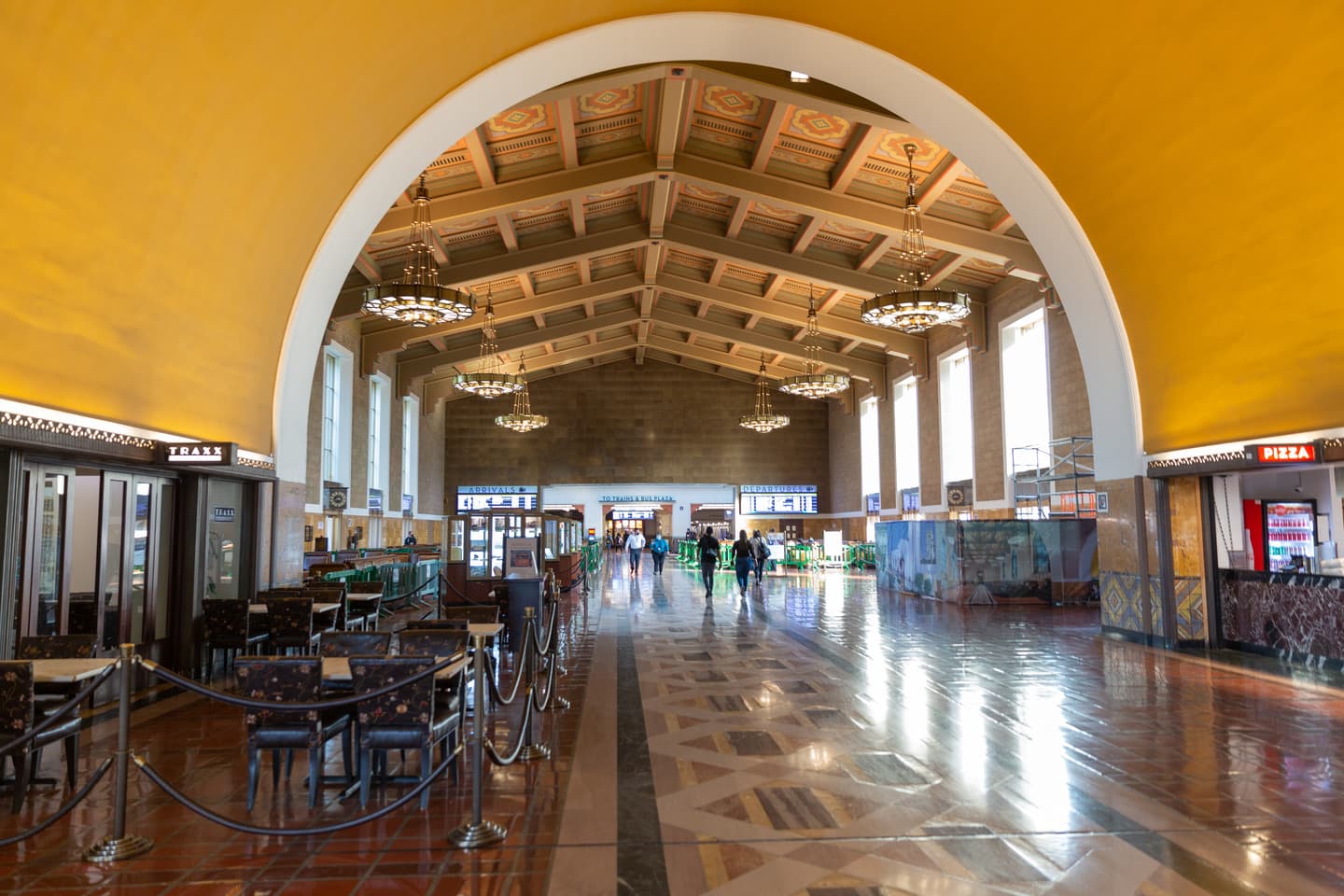 A long station hall with leather chairs, tiled floor and a beamed ceiling