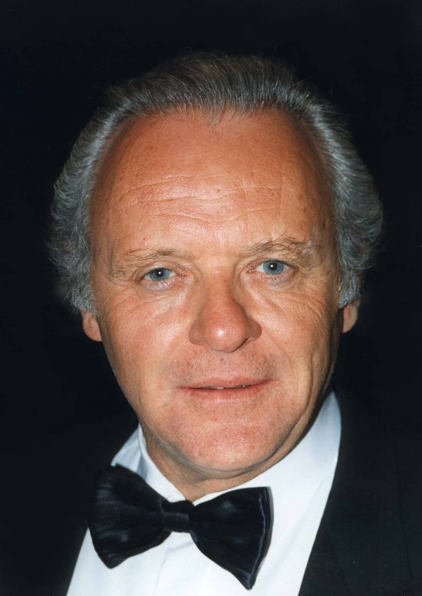 Anthony Hopkins in a black bow tie, smiling slightly against a dark background