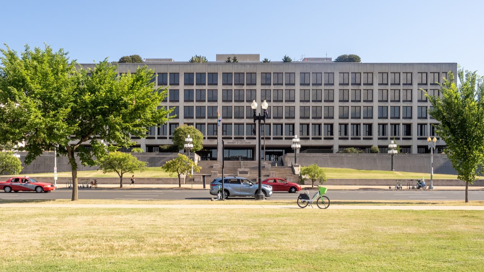 A long low office block behind trees and a wide lawn