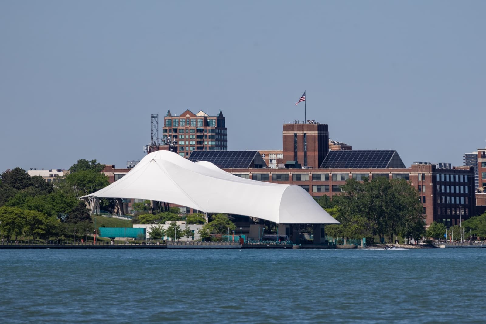 The white tented roof of the Aretha Franklin Amphitheatre beside the Detroit River