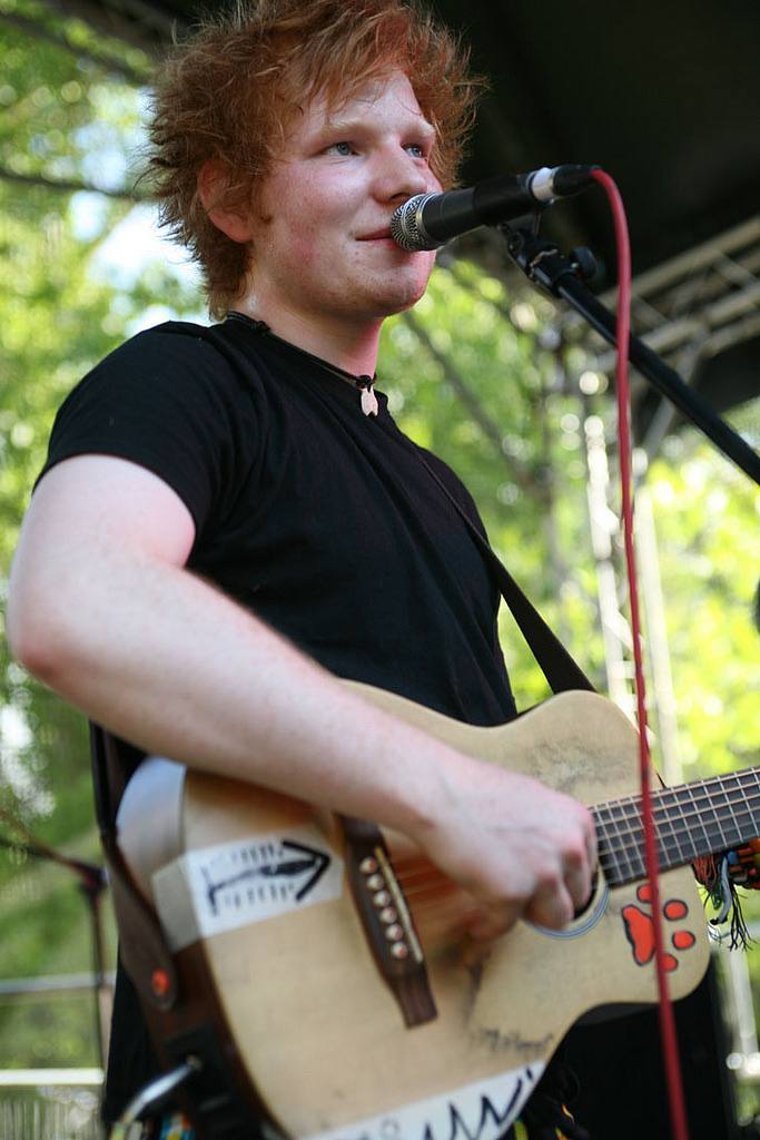 Ed Sheeran, aged nineteen, singing with an acoustic guitar at an outdoor festival in Ipswich in 2010