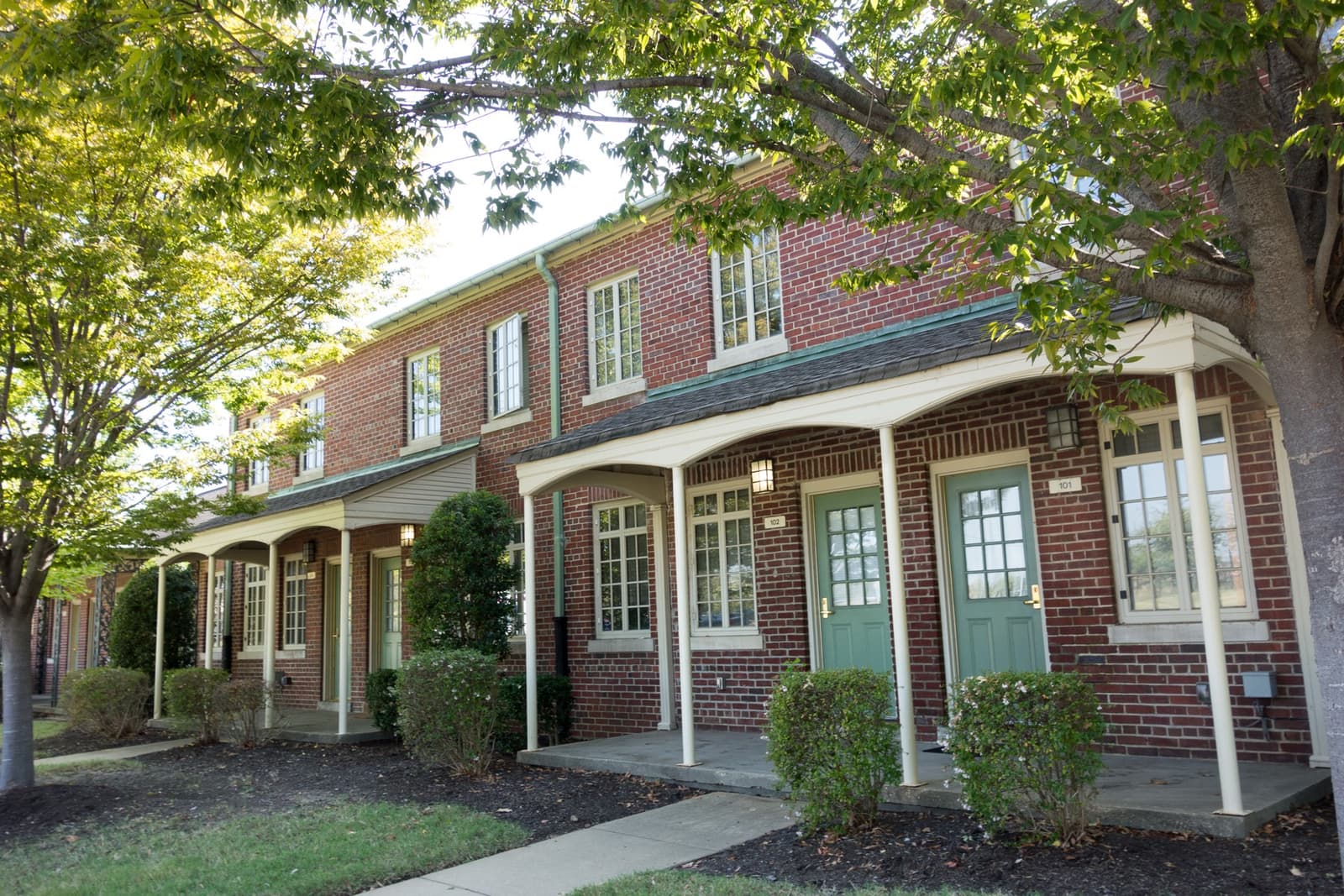 Two-storey brick apartment buildings around a lawn