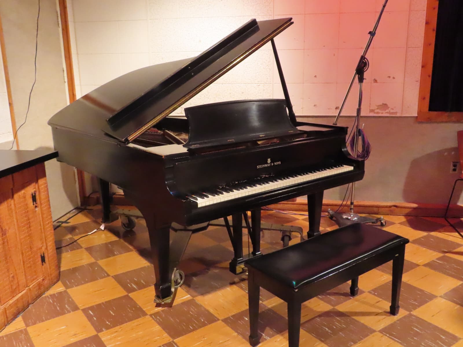 A grand piano in a small recording studio