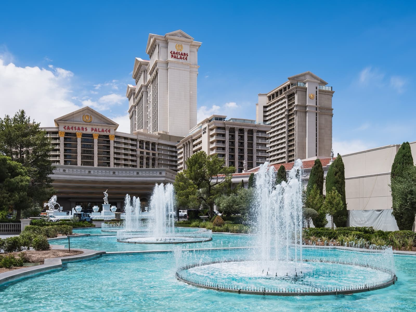 Hotel towers behind fountains and cypress trees