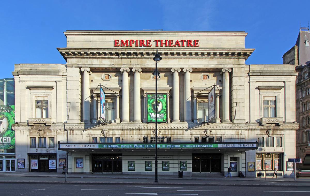 A grand pale stone theatre front with columns and EMPIRE THEATRE in red letters along the top