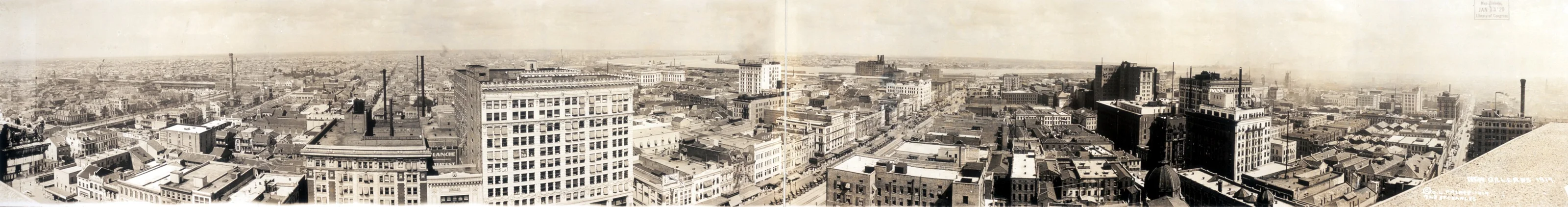 A wide panorama of New Orleans in 1919: rooftops, church spires and the river
