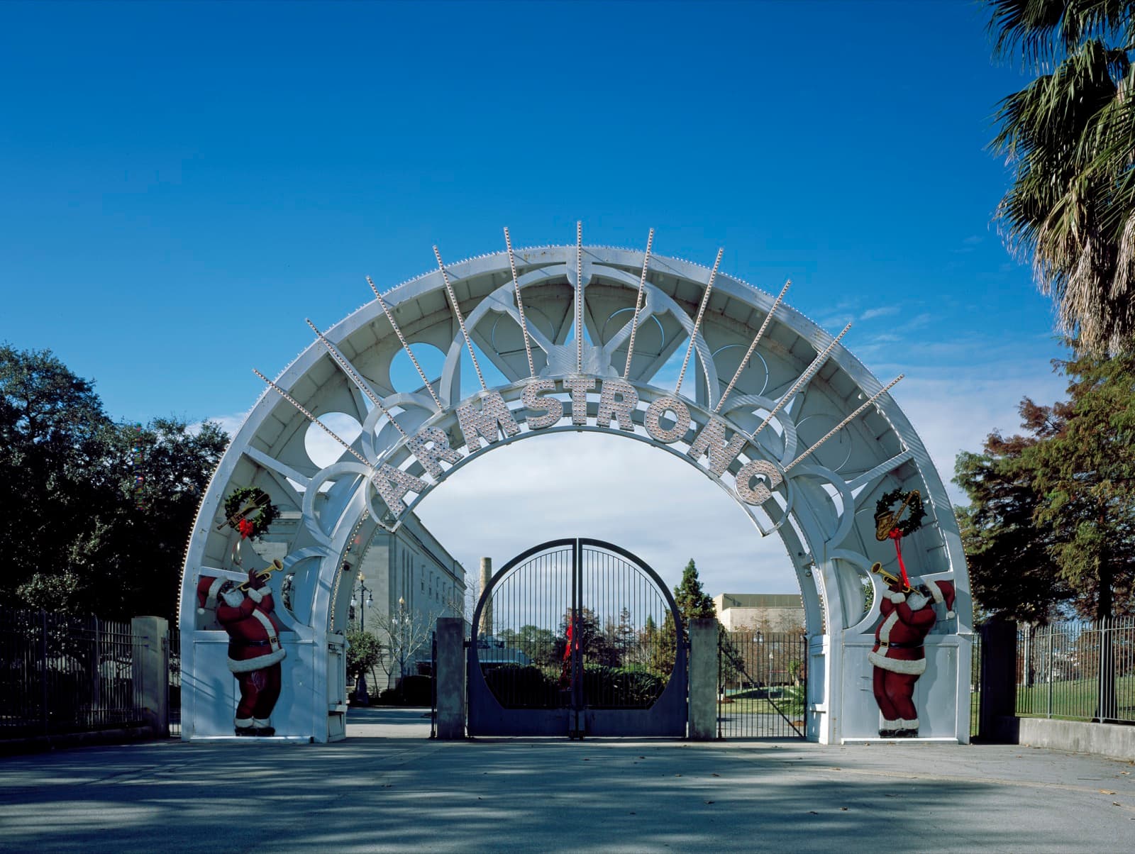 The illuminated entrance arch of Louis Armstrong Park, its name spelled across the top