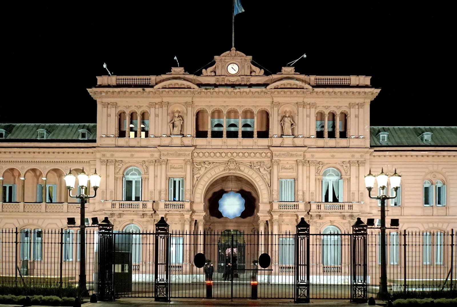 The pink facade of the Casa Rosada lit at night