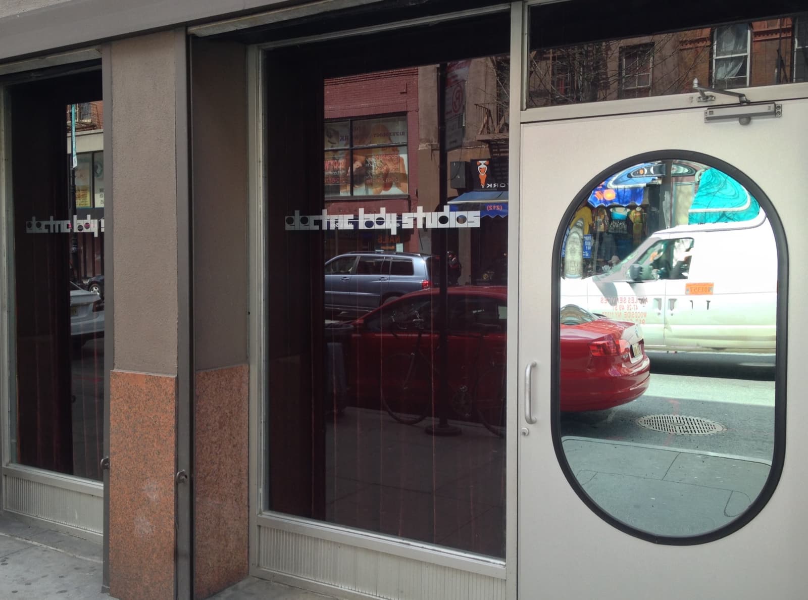 A glass shopfront and a door with an oval window, the studio's name lettered on the glass