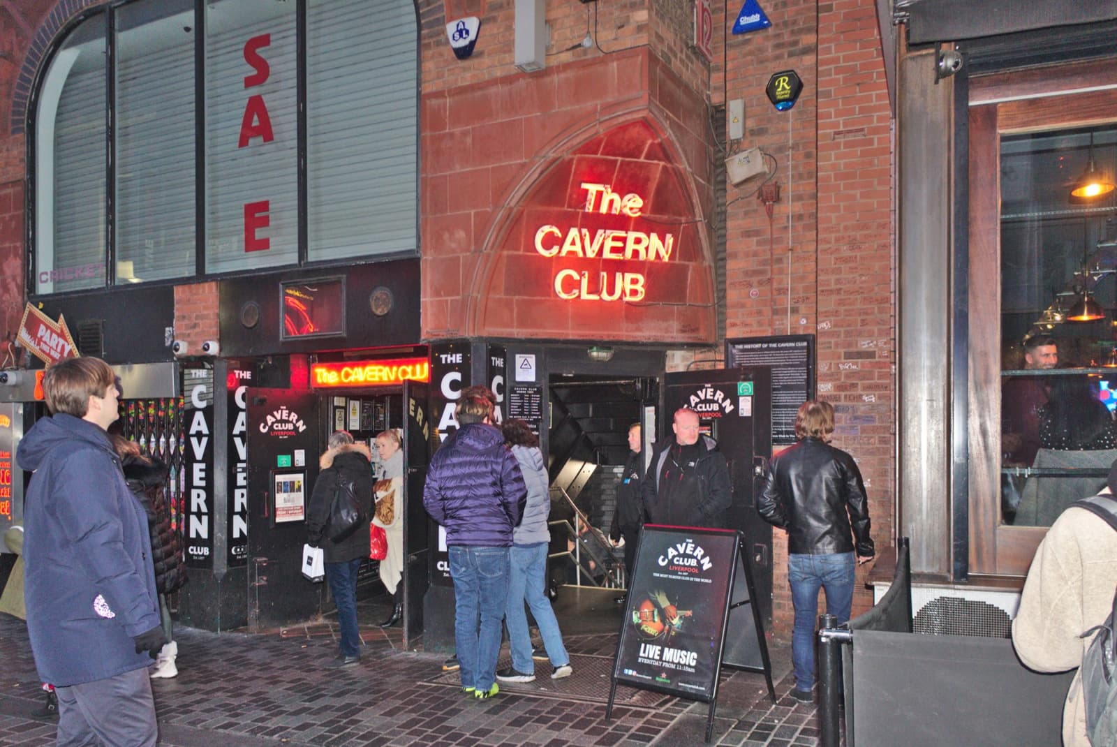 The arched entrance of a club on a narrow brick street