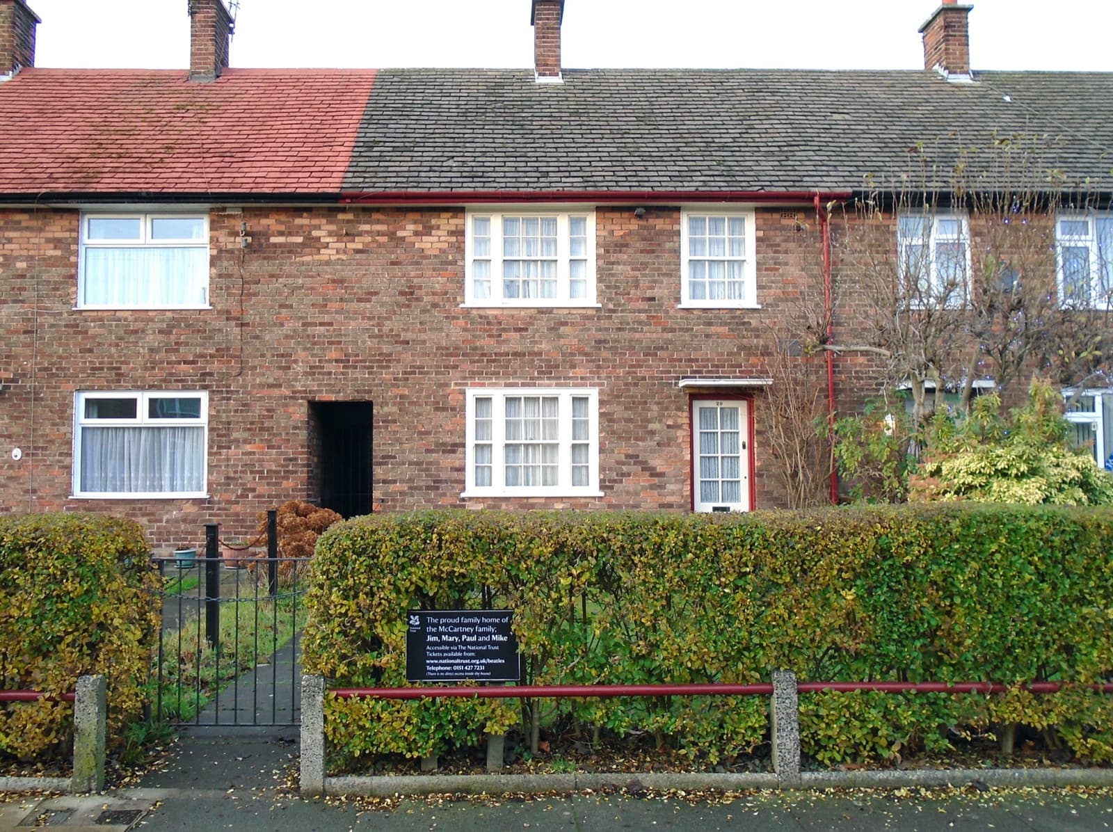 A plain brick terraced house with a small front garden