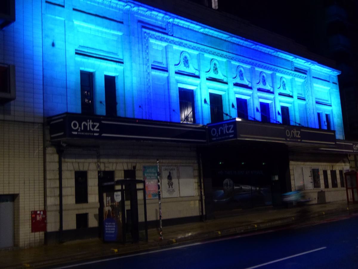 The Ritz’s long white facade lit blue at night