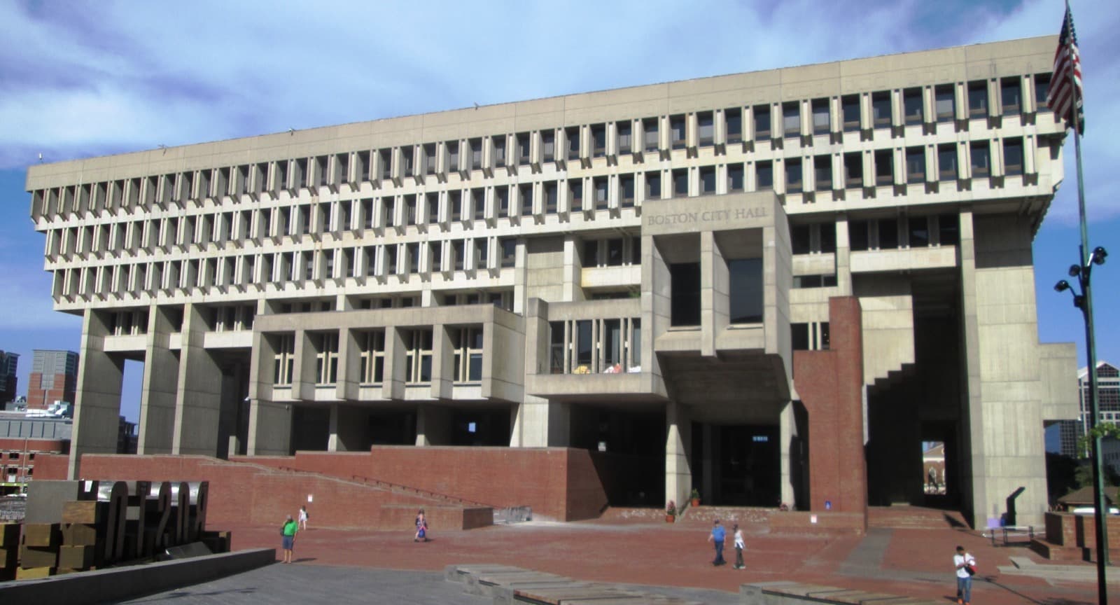 The concrete block of Boston City Hall above its brick plaza