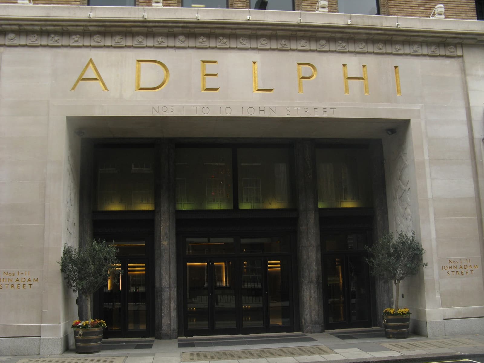The grand stone entrance of the Adelphi building with sculpted figures