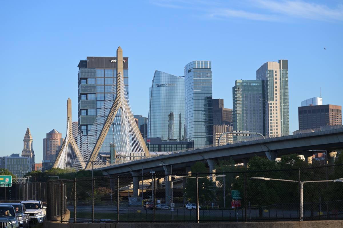 The white cable-stayed towers of the Zakim Bridge in front of Boston towers