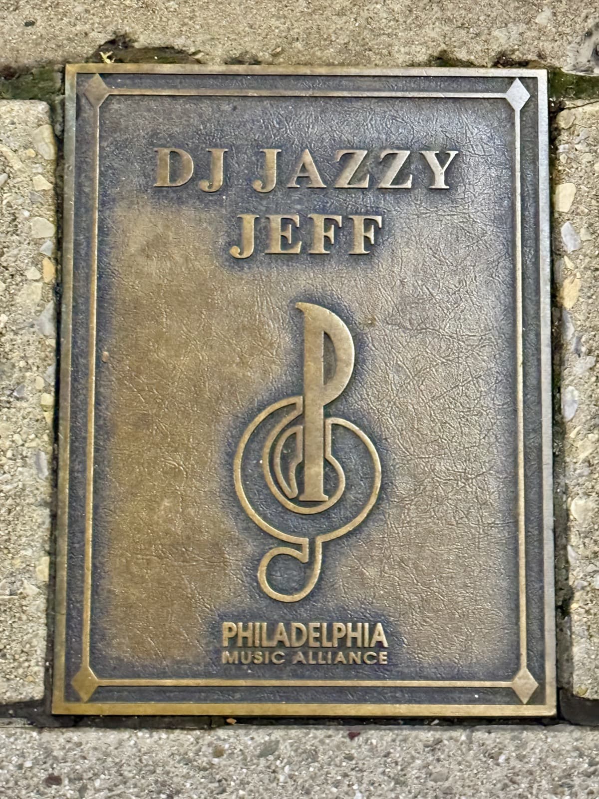 A bronze plaque set into a pavement, engraved with DJ Jazzy Jeff’s name