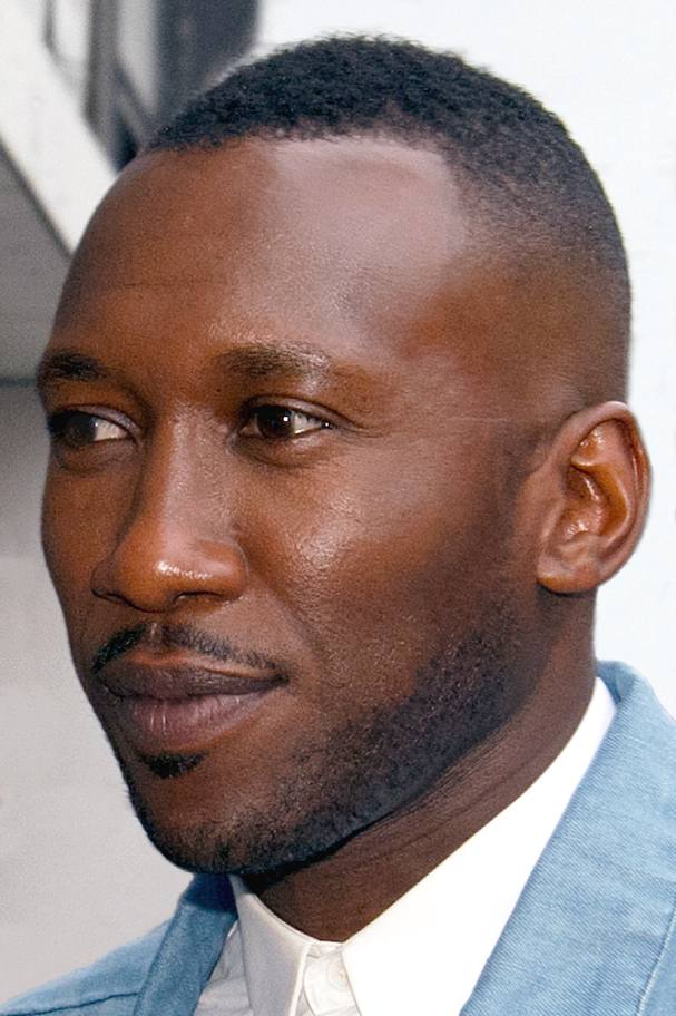 Mahershala Ali, smiling, in a dark suit