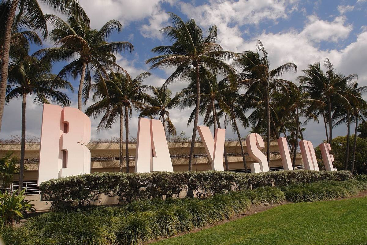 Tall pink letters spelling Bayside under palm trees