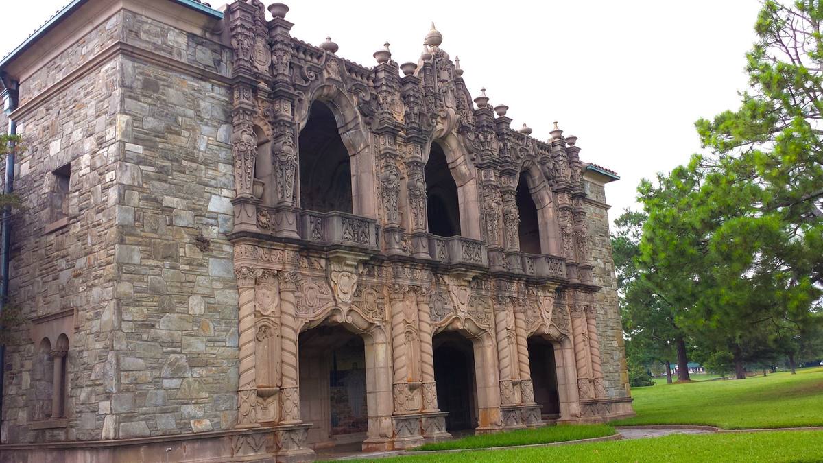 An ornate stone mausoleum facade with arched openings and carved tracery
