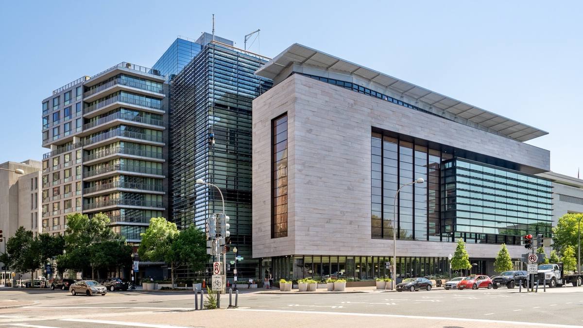 A modern stone and glass building on a wide street corner