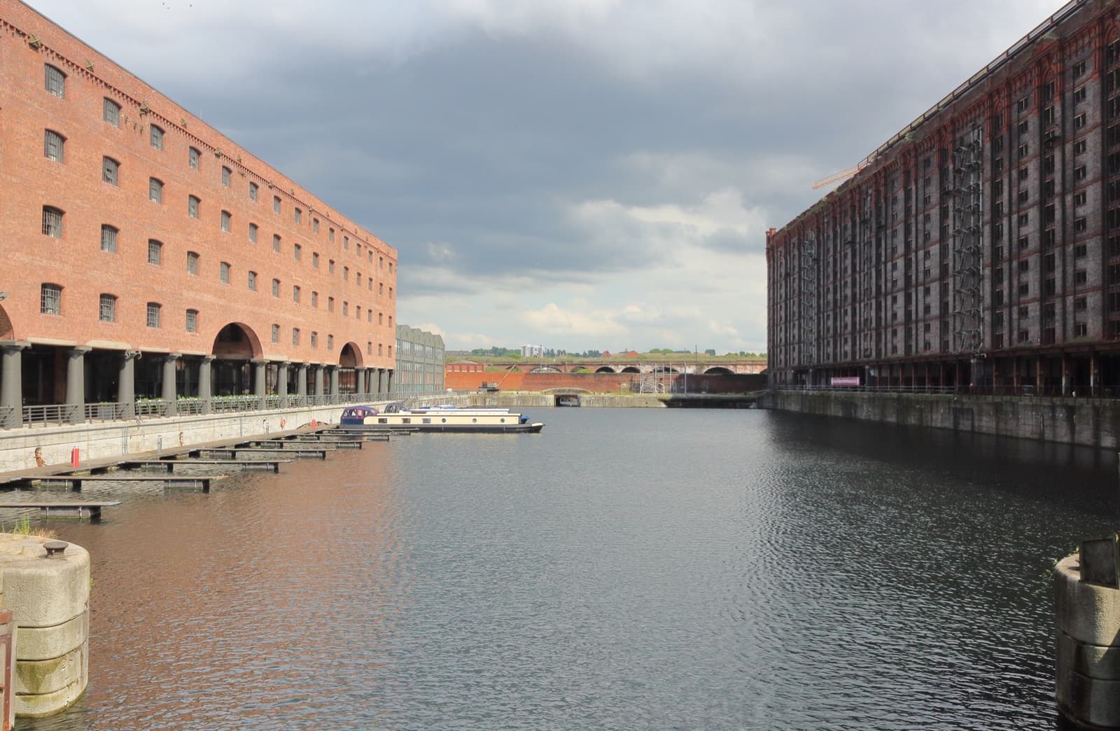 A still dock between two long brick warehouses