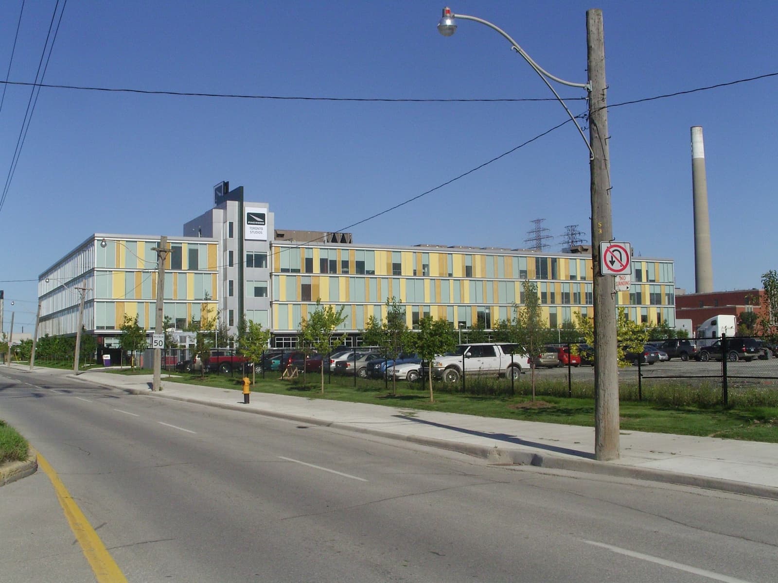 Low studio buildings and a car park on a wide Toronto street