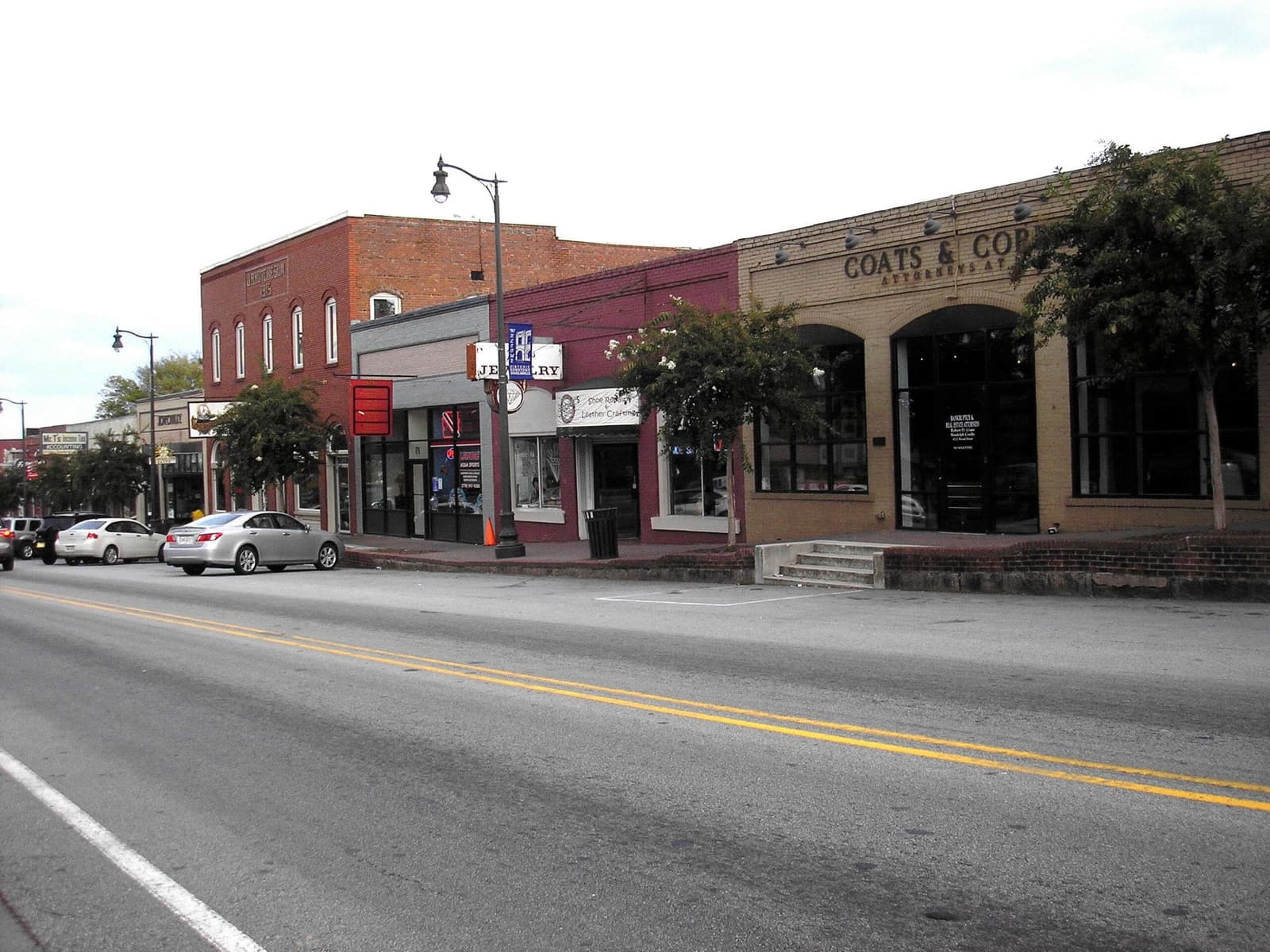 A row of brick shopfronts along a quiet main street