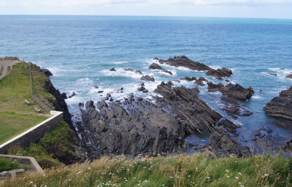 Folded grey cliffs and a rocky shore