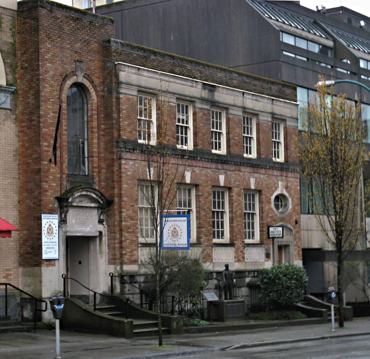 A two-storey brick and stone civic building with an arched doorway on a Vancouver street